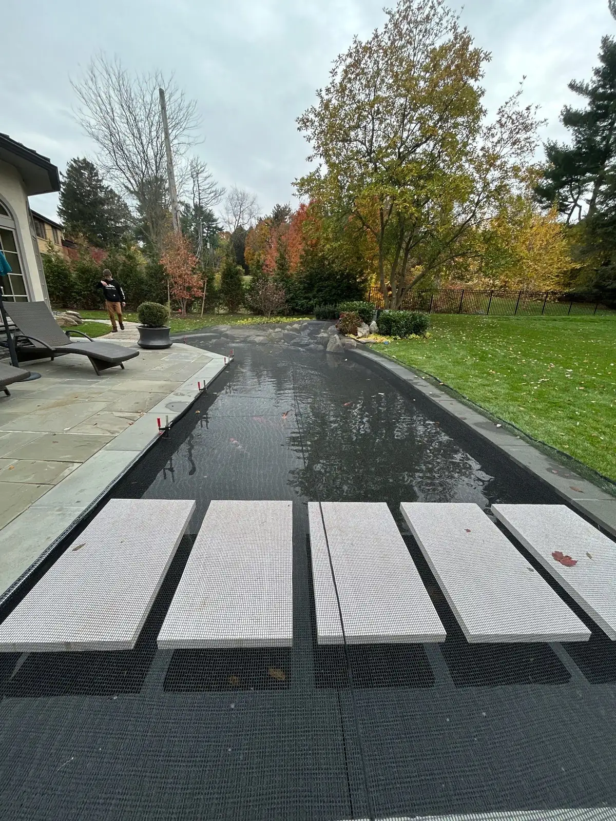 Dome netting installed over pond catching falling autumn leaves