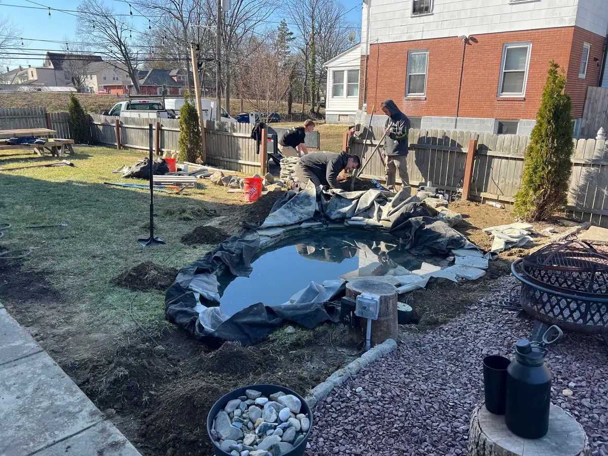Pond construction in progress showing crew installing liner in Hockessin, DE
