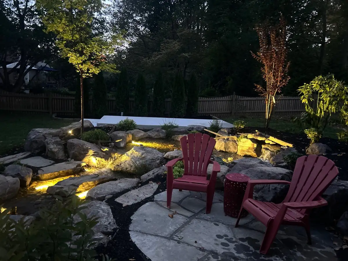 Illuminated water feature and stone pathway at night