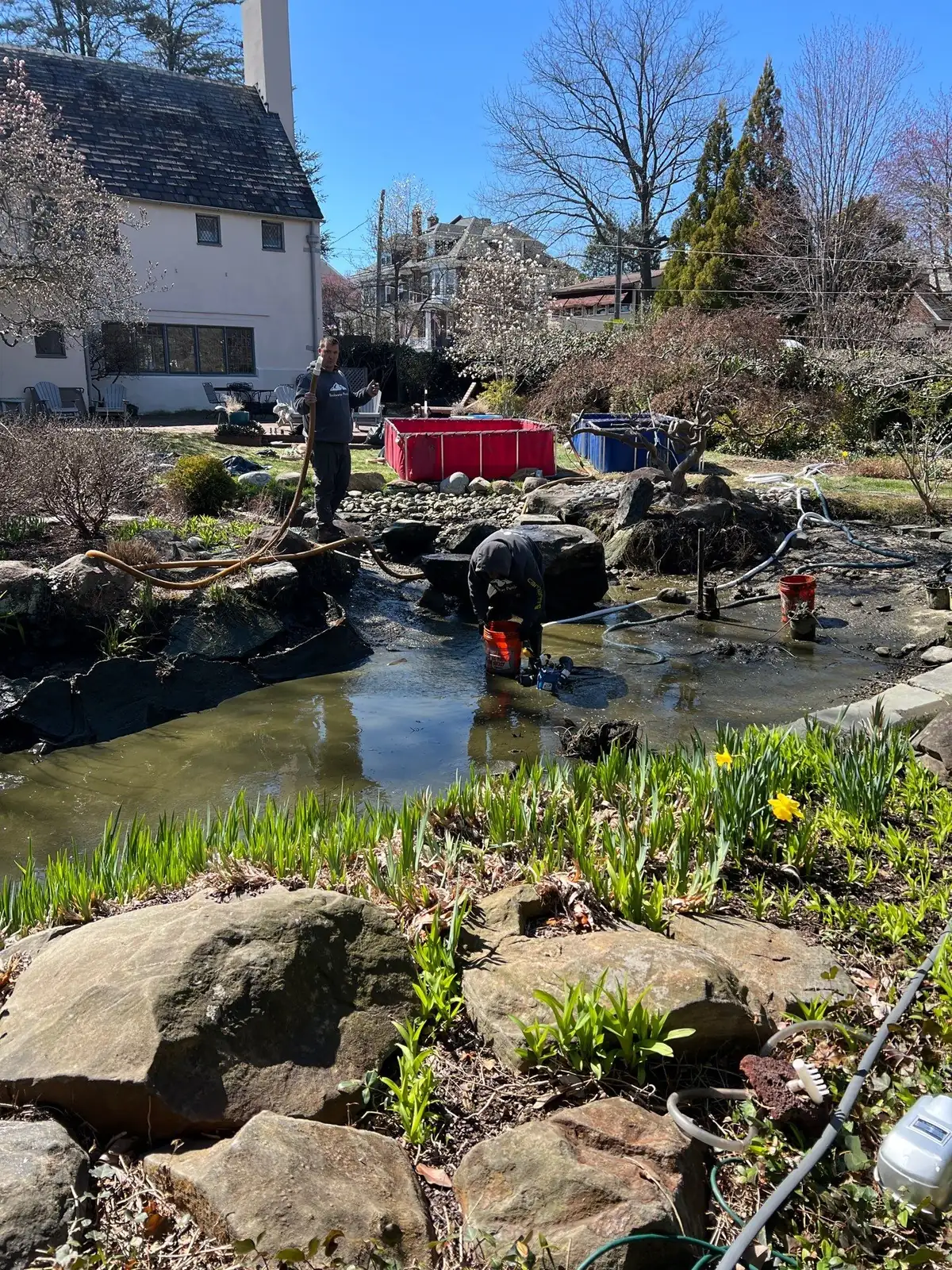 Crew performing spring pond cleanout with debris removal