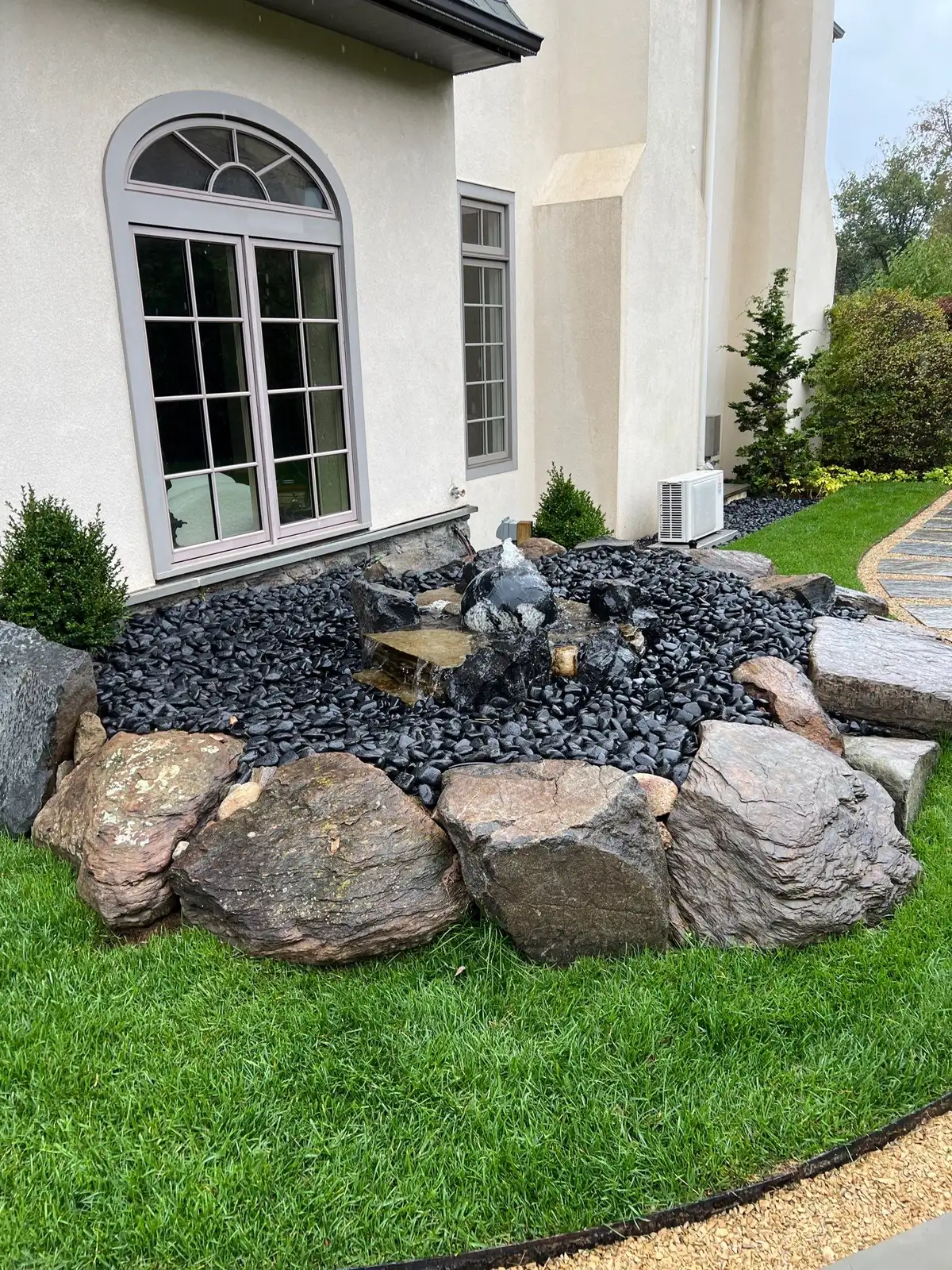 Large-scale pond construction with heavy equipment and boulder work
