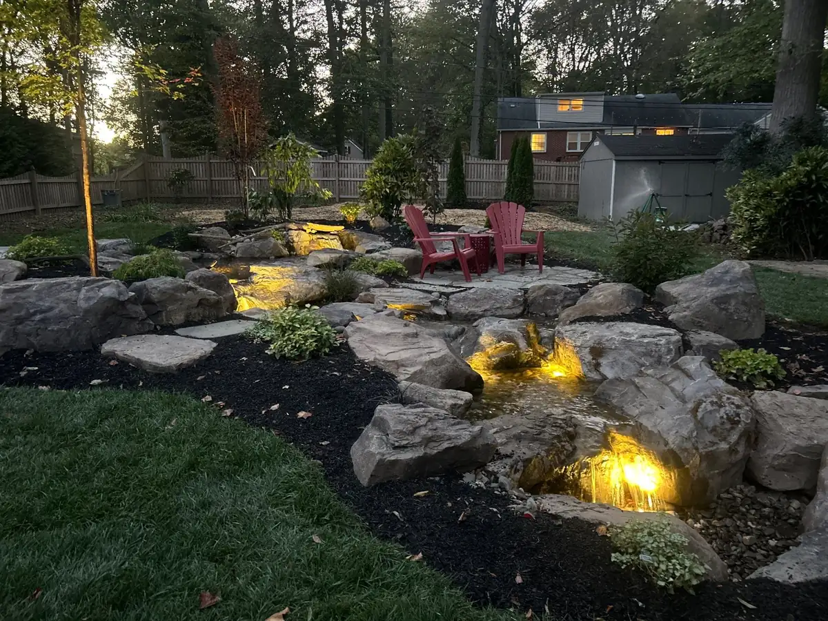 Multi-tier waterfall design with natural stone and aquatic plantings